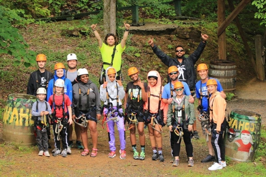 A happy family group getting ready for an outdoor adventure at Wahoo Ziplines.